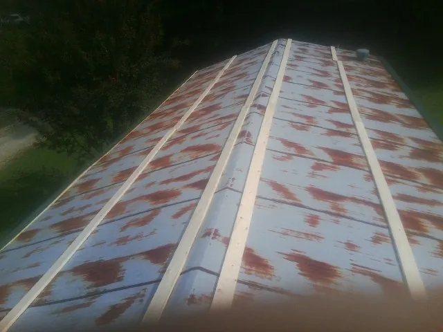 Rusted metal roof panels with new wood purlins before replacement — Storm Damage Roof Repair in Arizona City by Roofing Brothers